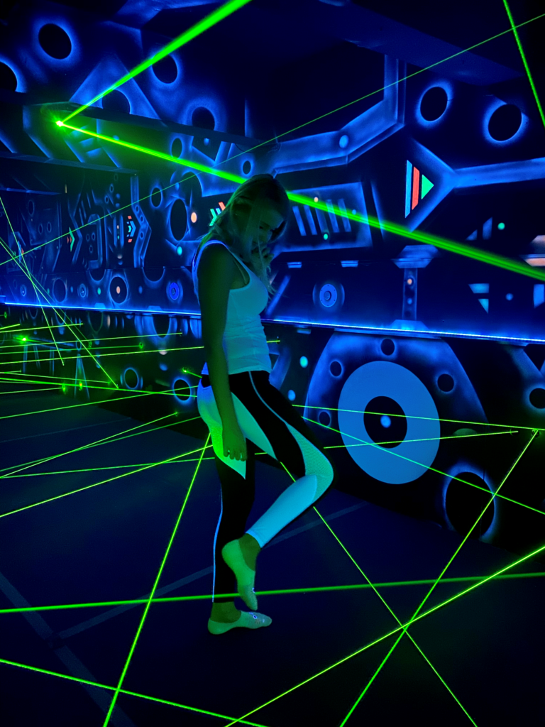 A lady crossing one of the green laser beams in the areas of the Laser Labyrinth in Brno