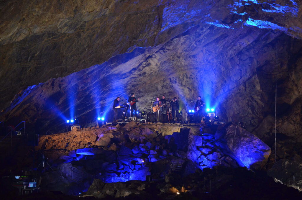A musical ensemble in the spaces of the blue-lit cave