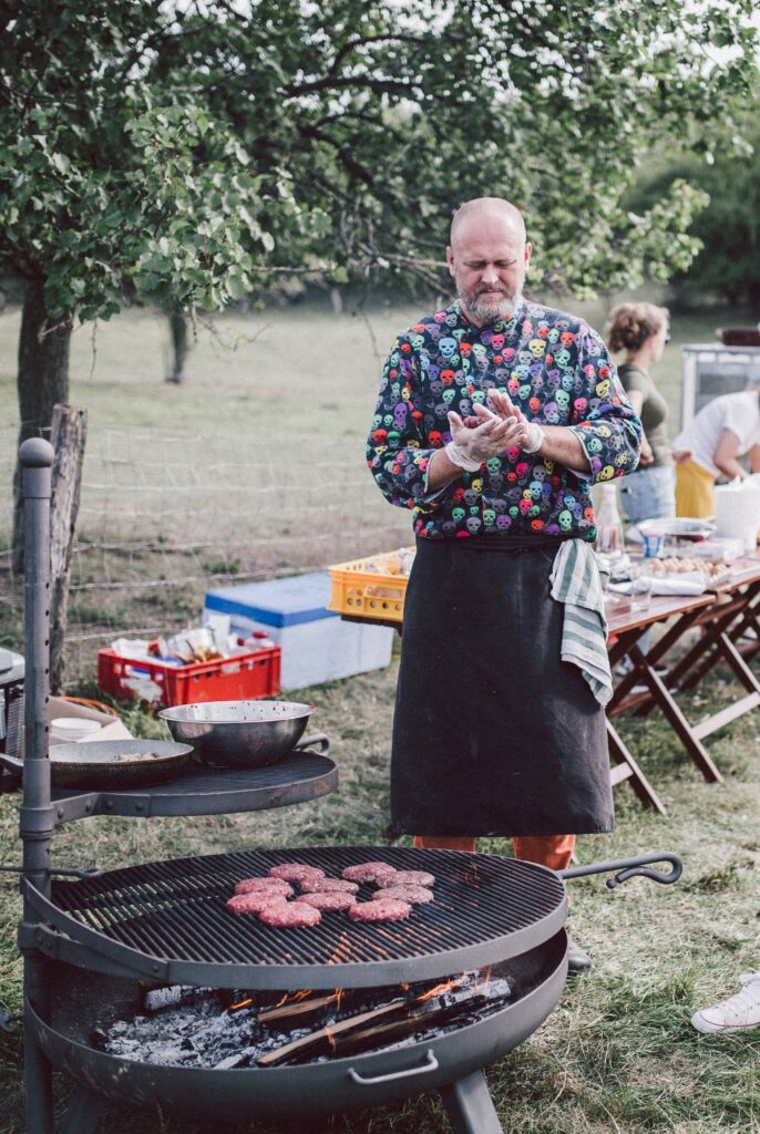 Chef standing by the grill on which there are hamburgers