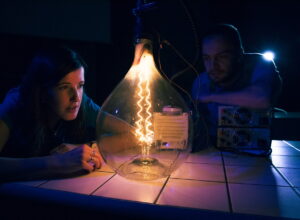 Vida science center after dark with a large light bulb