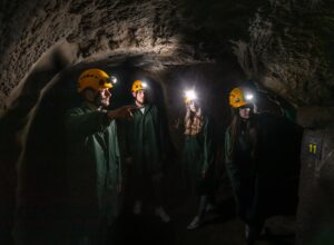 Four people with helmets on yellow helmets in the Znojmo underground