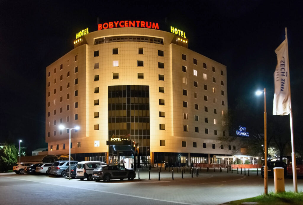 The night exterior of the Cosmopolitan Bobycentrum hotel photographed from the parking lot